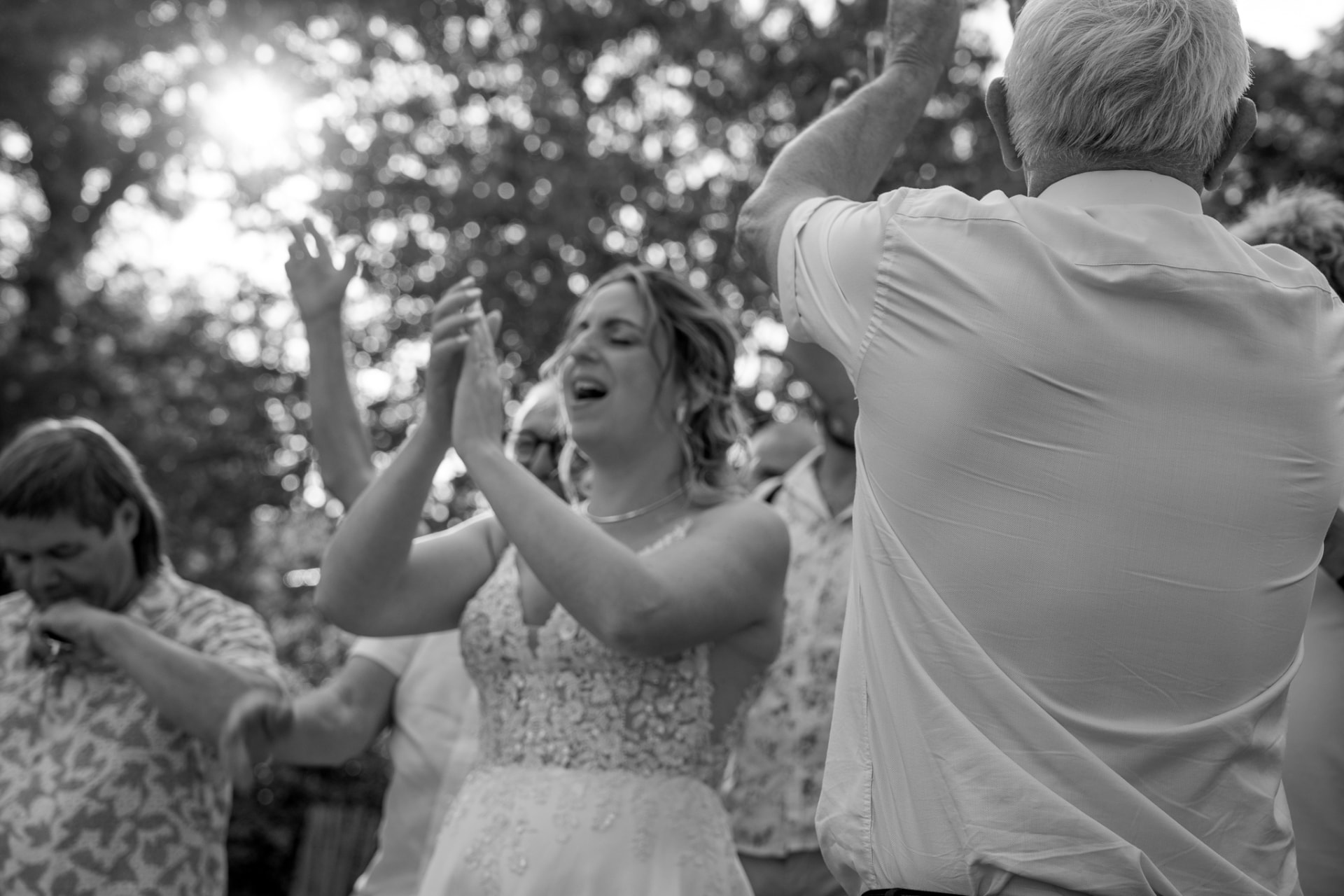 La mariée dansant au milieu de ses invités, en noir et blanc