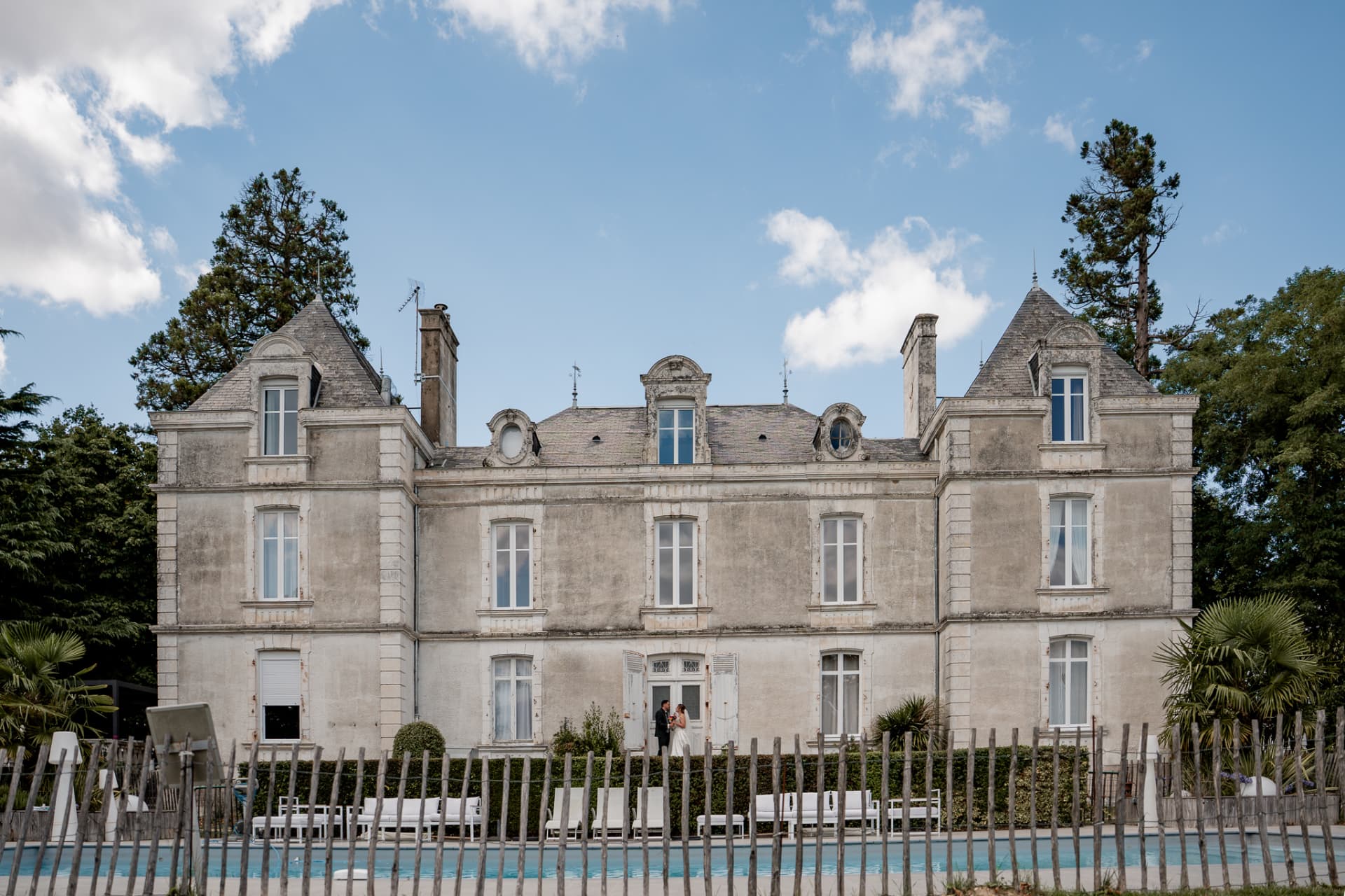 Les mariés minuscules devant un grand château