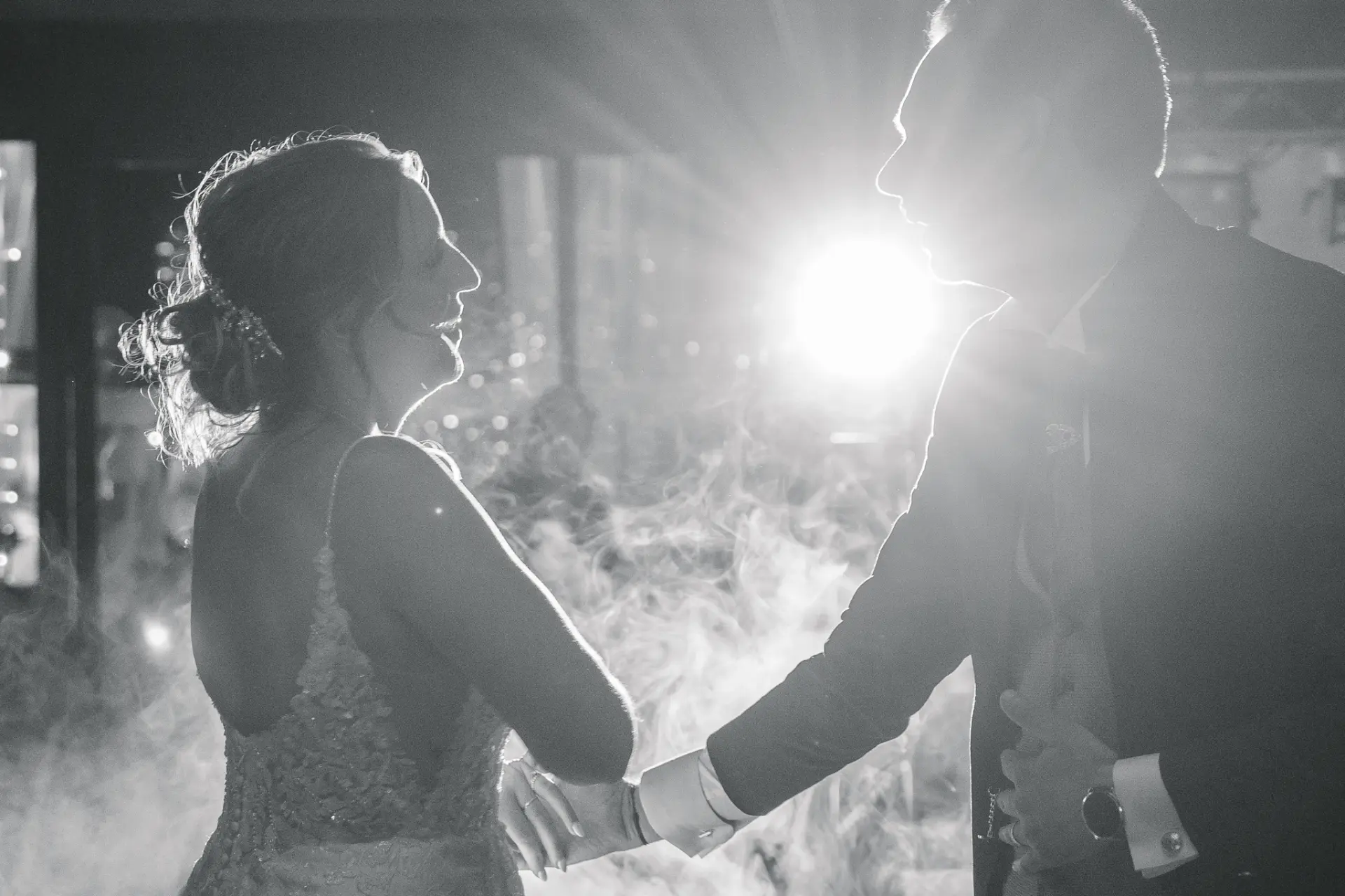 Silhouettes des mariés à contre-jour pendant l'ouverture de bal, en noir et blanc