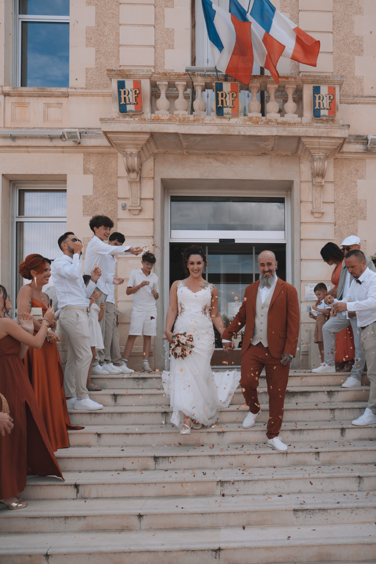 Les mariés descendent les marches sous les pétales lancés par leurs proches