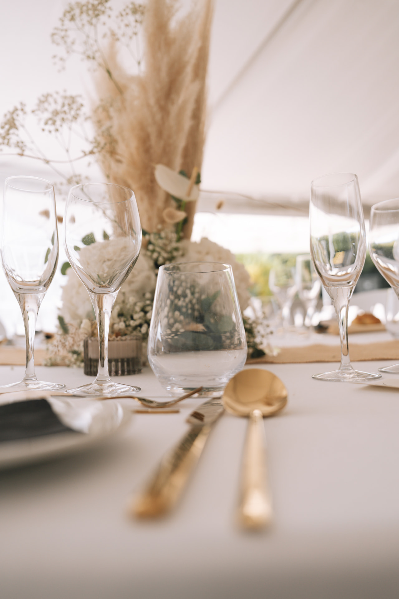 Détail d'une table dressée avec pampas et couverts dorés