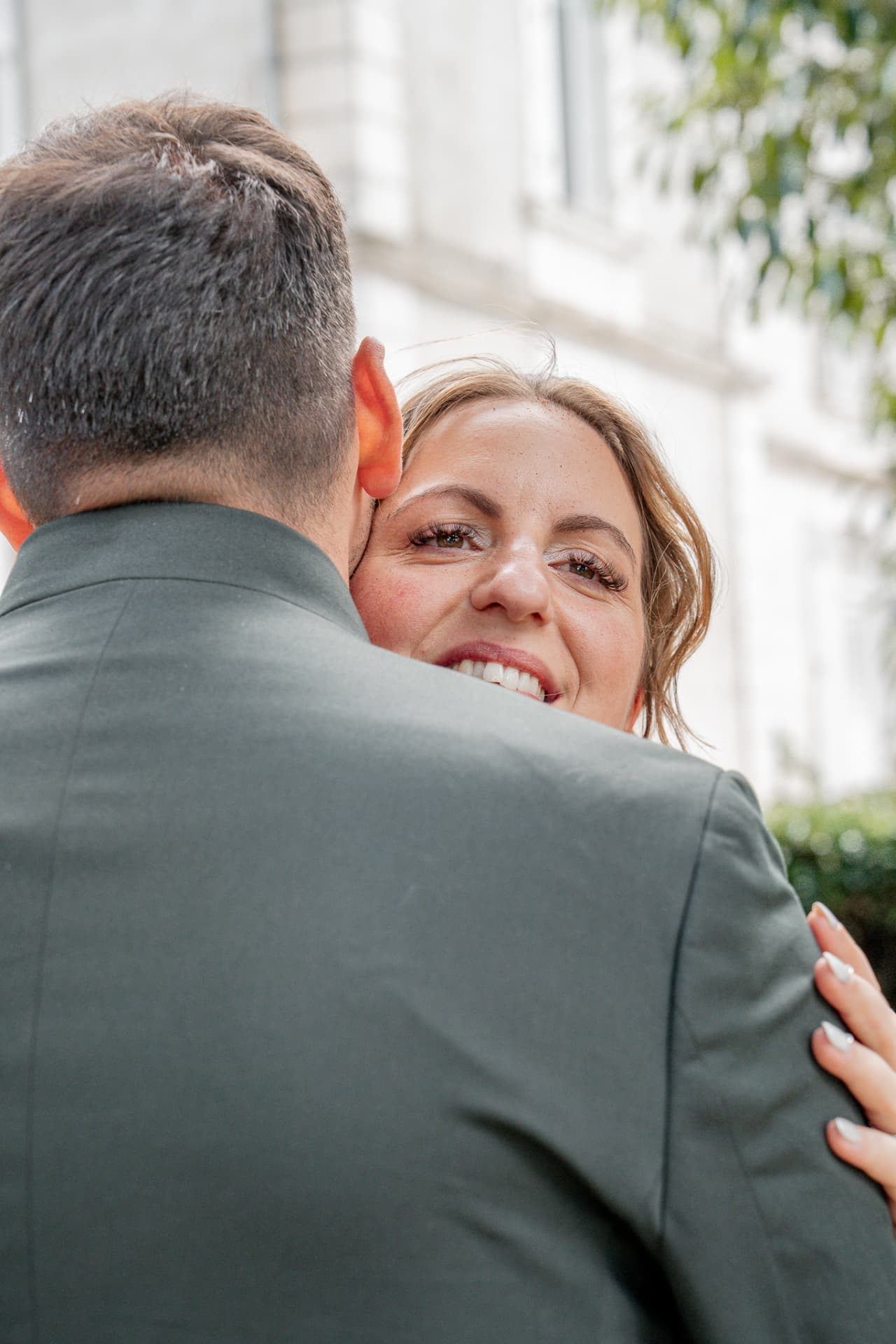 La mariée sourit blottie sur l'épaule de son mari